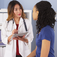  female doctor speaking with female patient